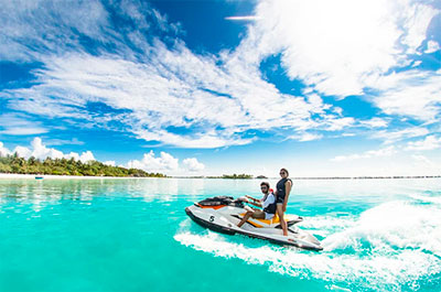 Pareja en moto acuatica en aguas azul turquesa