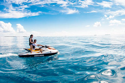chico y chica en una moto de agua en el mar azul